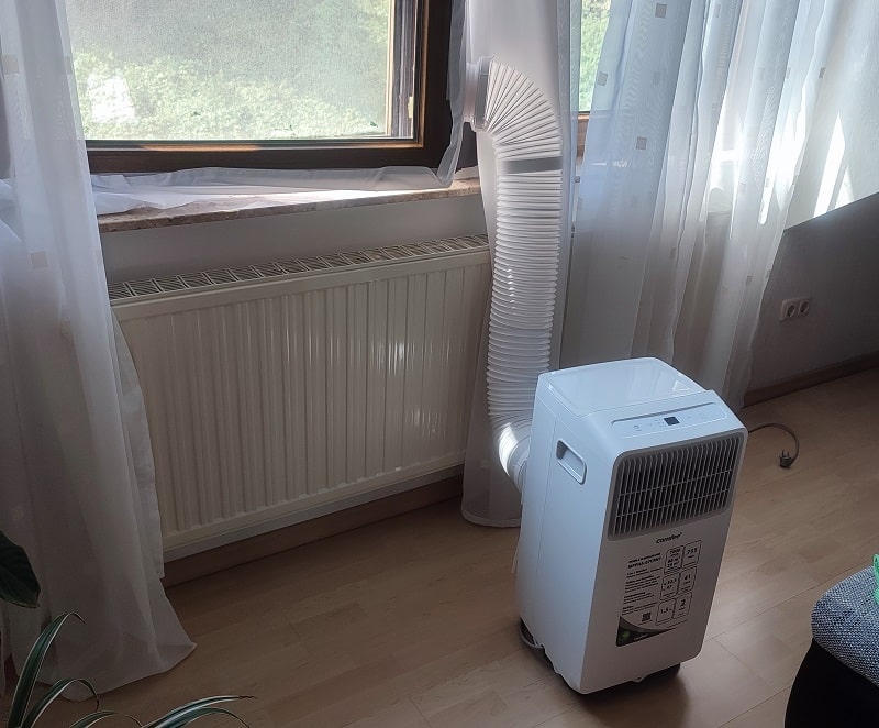 portable air conditioner installed at a window viewed from an angle